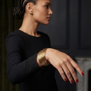 Pulsera Multicapa Solstice de aros dorados entrelazados, puesta en la muñeca